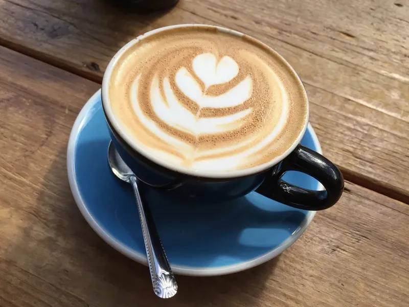 Latte art in a blue cup on a wooden table